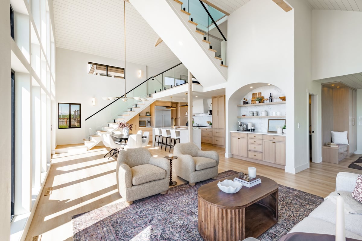 Elegant modern home interior with floor to ceiling windows, vaulted ceiling and waterfront views