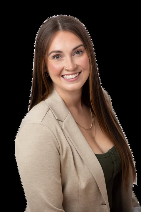 Professional headshot of a smiling woman with long brown hair wearing a beige cardigan over a dark top against a black background