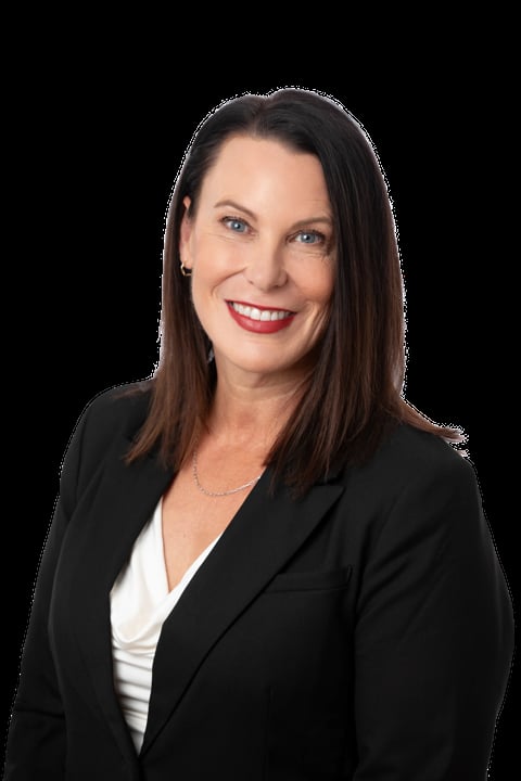 Professional headshot of a woman with long dark hair wearing a black blazer and white top, smiling against a black background